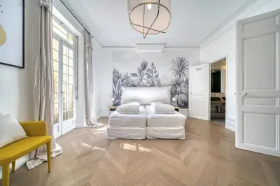 a white bedroom with a bed and a couch at REF 1412 - Cannes Center - Apartment for rent in Cannes