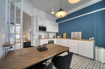 a kitchen with a wooden table and a blue wall at REF 1412 - Cannes Center - Apartment for rent in Cannes