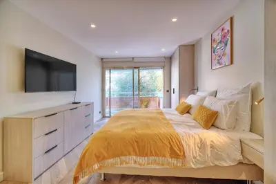 a bedroom with a large bed with a flat screen tv at REF 1442 - Cannes Center - Apartment for rent in Cannes