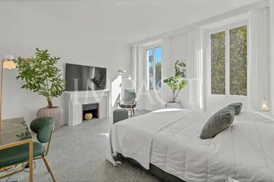 a white bedroom with a bed and a fireplace at REF 783 - Cannes Croisette - Apartment for rent in Cannes