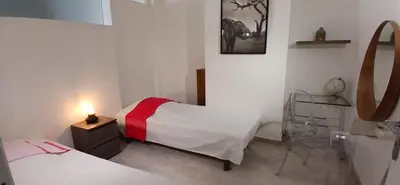 a room with two beds and a table with a lamp at Bel appartement central 2 chambres in Cannes
