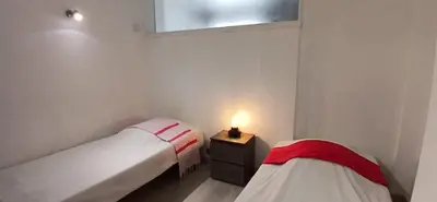 two beds in a room with a lamp on a table at Bel appartement central 2 chambres in Cannes