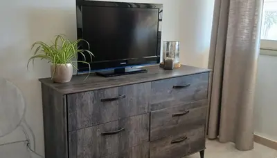 a wooden dresser with a television on top of it at Bel appartement central 2 chambres in Cannes