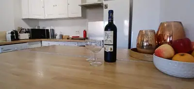 a bottle of wine and a bowl of apples on a kitchen counter at Bel appartement central 2 chambres in Cannes