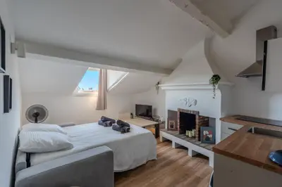 a white bedroom with a bed and a fireplace at Cozy T2 Centre Cannes proche Suquet in Cannes