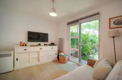 a living room with a flat screen tv and a window at FRGK Villa Bohème Chic Private Pool UltraFast WiFi in Le Cannet