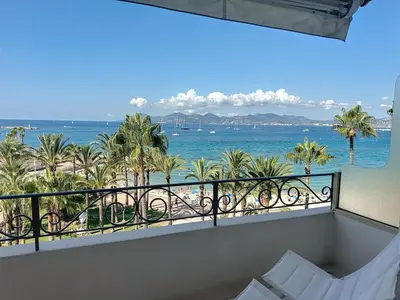 a balcony with a view of the ocean and palm trees at Bright one bedroom apartment on La Croisette in Cannes