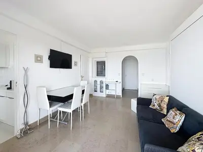 a living room with a couch and a table and chairs at Bright one bedroom apartment on La Croisette in Cannes