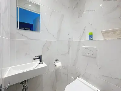 a white bathroom with a sink and a toilet at Bright one bedroom apartment on La Croisette in Cannes