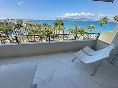 a white chair on a balcony with a view of the ocean at Bright one bedroom apartment on La Croisette in Cannes