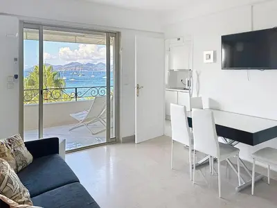 a living room with a couch and a table with chairs at Bright one bedroom apartment on La Croisette in Cannes