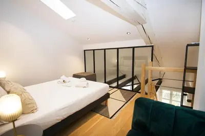 a bedroom with a bed and a chair in a room at L'Ecrin Festivalier Standing Presta in Cannes