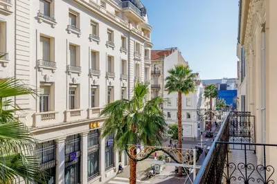 a city street with palm trees and buildings at L'Ecrin Festivalier Standing Presta in Cannes