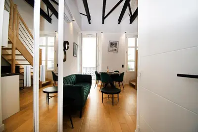 a living room with a green couch and a table at L'Ecrin Festivalier Standing Presta in Cannes