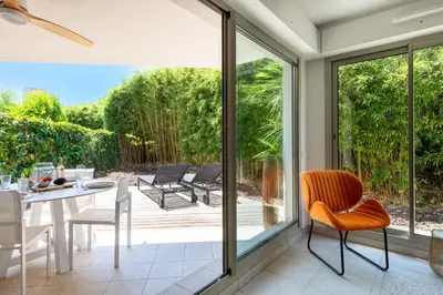 a dining room with sliding glass doors leading to a patio at 1-Br Garden Apartment with Pool Peaceful Private Parking in Cannes