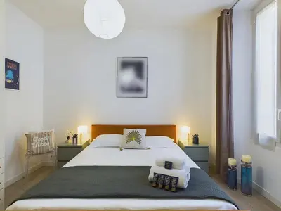 a bedroom with a large bed with two pillows on it at Centre Cannes Serbes in Cannes