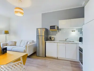 a kitchen with a stainless steel refrigerator in a room at Centre Cannes Serbes in Cannes