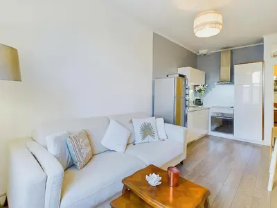 a living room with a white couch and a table at Centre Cannes Serbes in Cannes