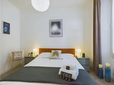 a bedroom with a large white bed with two pillows at Centre Cannes Serbes in Cannes