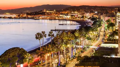 a city with palm trees and the ocean at night at Sea view, Luminous, Terrace, Garage, AC, Design in Cannes