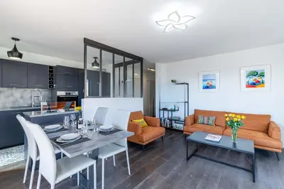 a kitchen and living room with a table and a couch at Sea view, Luminous, Terrace, Garage, AC, Design in Cannes