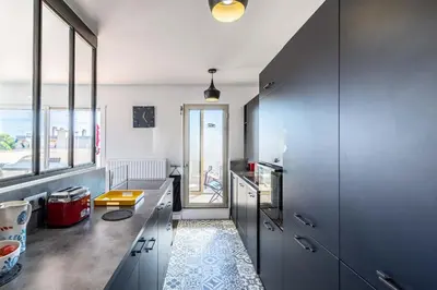 a kitchen with gray cabinets and a large window at Sea view, Luminous, Terrace, Garage, AC, Design in Cannes