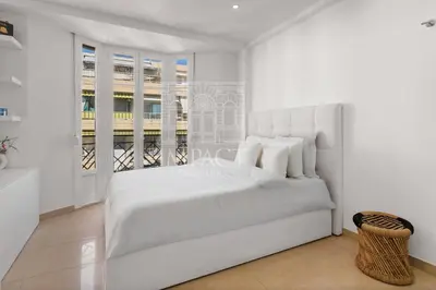 a white bedroom with a white bed and a window at REF 2019 - Apartment for rent Cannes Center in Cannes