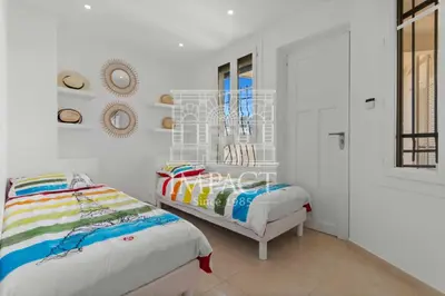 two beds in a room with white walls at REF 2019 - Apartment for rent Cannes Center in Cannes