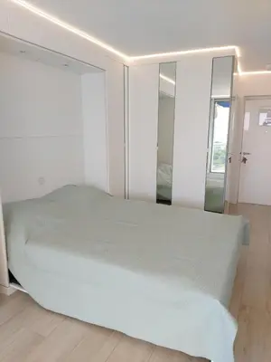 a bedroom with a large bed and a mirror at Studio Cannes beautiful sea view in Cannes