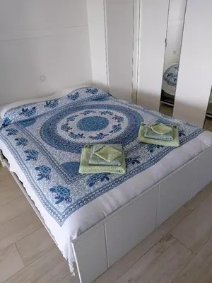 a bed with a blue and white quilt on it at Studio Cannes beautiful sea view in Cannes