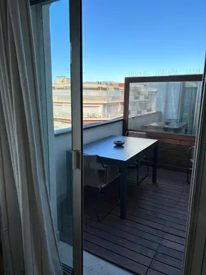 a balcony with a table and a window at Lovely 2 pièces Croisette Martinez in Cannes