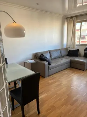 a living room with a couch and a table at Lovely 2 pièces Croisette Martinez in Cannes