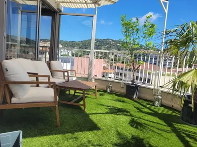 a patio with chairs and a table on a balcony at Rooftop apartment Cannes center - Parking in Cannes