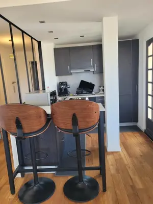 a kitchen with two bar stools in a room at Rooftop apartment Cannes center - Parking in Cannes
