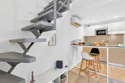 a kitchen with a spiral staircase in a apartment at Cosy Duplex Mimosa Cannes Center - Happy Rentals in Cannes