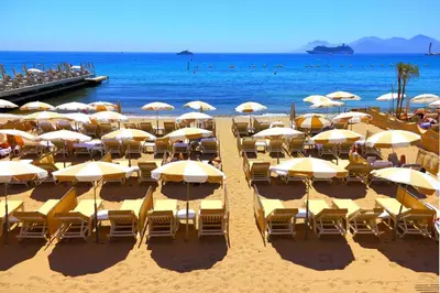 a bunch of chairs and umbrellas on a beach at Cosy Duplex Mimosa Cannes Center - Happy Rentals in Cannes