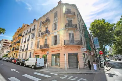 a large building on the corner of a city street at Cosy Duplex Mimosa Cannes Center - Happy Rentals in Cannes