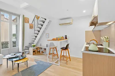 a kitchen and living room with a table and chairs at Cosy Duplex Mimosa Cannes Center - Happy Rentals in Cannes
