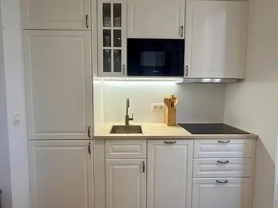 a kitchen with white cabinets and a sink at Lumière by Connexion in Cannes