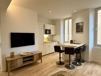 a living room with a table and a flat screen tv at Lumière by Connexion in Cannes
