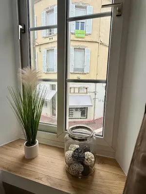 a window with a jar of shells on a window sill at Lumière by Connexion in Cannes