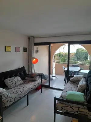 a living room with a couch and a table at Cannes plages du Midi Appartements climatisés Bord de mer de 1 à 6 pers, 2 piscines, Parking privatif inclus in Cannes