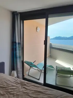 a bedroom with a view of the ocean from a window at Cannes plages du Midi Appartements climatisés Bord de mer de 1 à 6 pers, 2 piscines, Parking privatif inclus in Cannes
