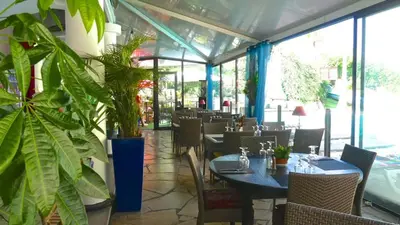 a restaurant with tables and chairs and plants at Cannes plages du Midi Appartements climatisés Bord de mer de 1 à 6 pers, 2 piscines, Parking privatif inclus in Cannes