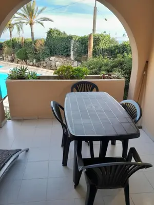 a table and chairs on a balcony with a view of a pool at Cannes plages du Midi Appartements climatisés Bord de mer de 1 à 6 pers, 2 piscines, Parking privatif inclus in Cannes