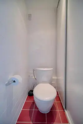 a white toilet in a bathroom with a red floor at Immogroom - 1 Bedroom - Sea view- AC in Cannes