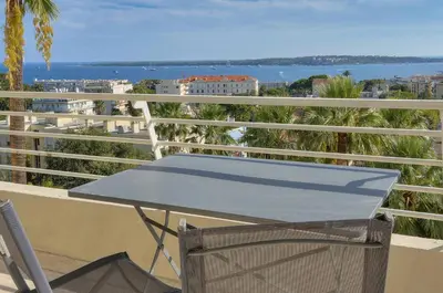a table and chair on a balcony with a view of the ocean at Immogroom - 1 Bedroom - Sea view- AC in Cannes