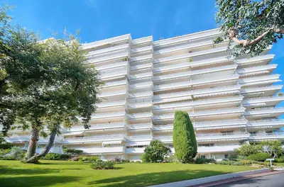 a large white building with trees in front of it at Immogroom - 1 Bedroom - Sea view- AC in Cannes