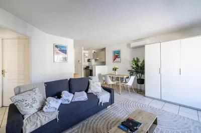 a living room with a blue couch and a table at Bright One bedroom Apt with Parking and Terrace in Cannes