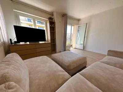 a living room with a couch and a flat screen tv at 2 pièces Cannes centre Terrasse et plage à 5 min in Cannes